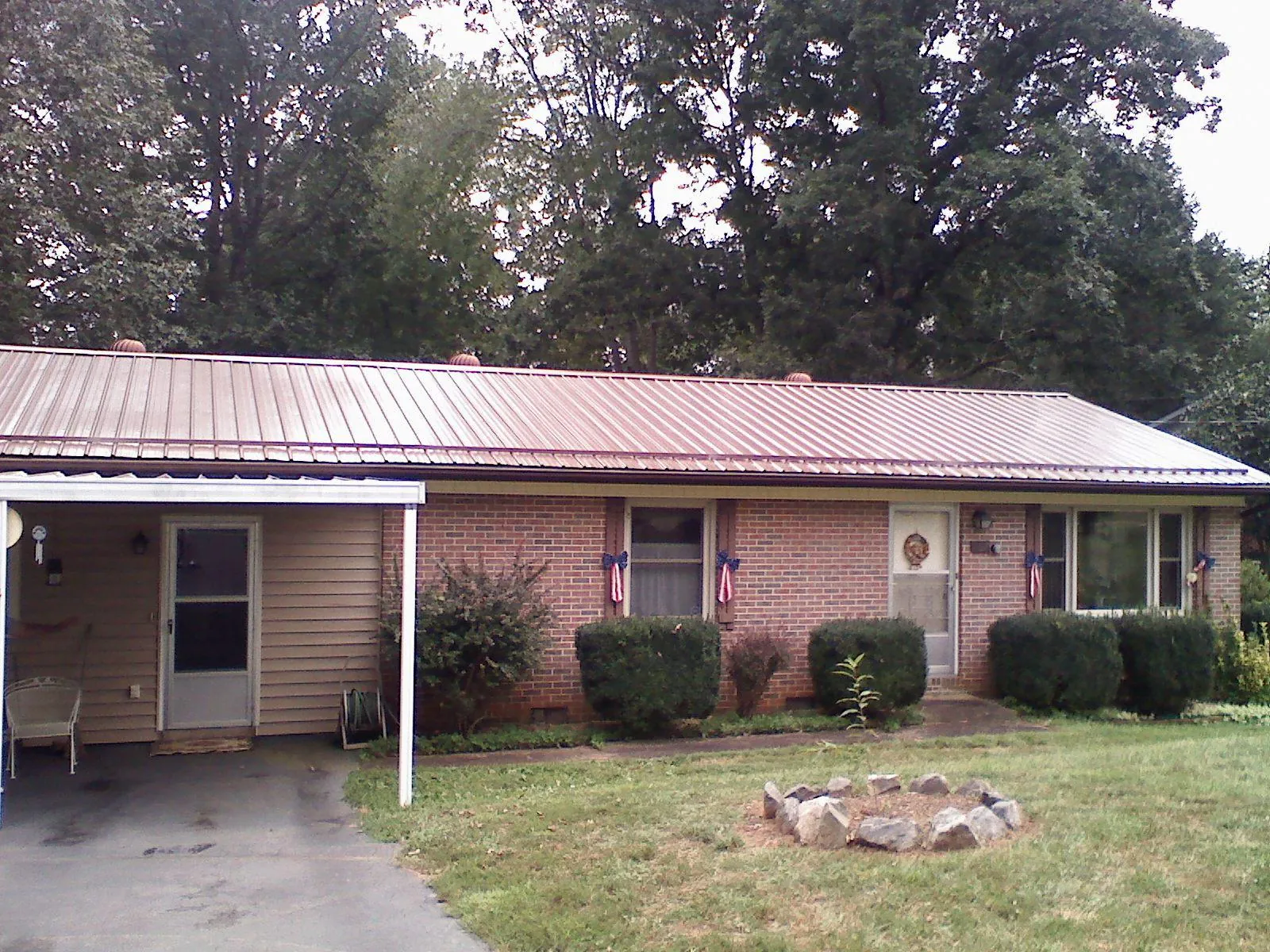 Bronze metal roof and carport on a brick ranch home — Roof Repair work by our crew in Ponte Vedra Beach